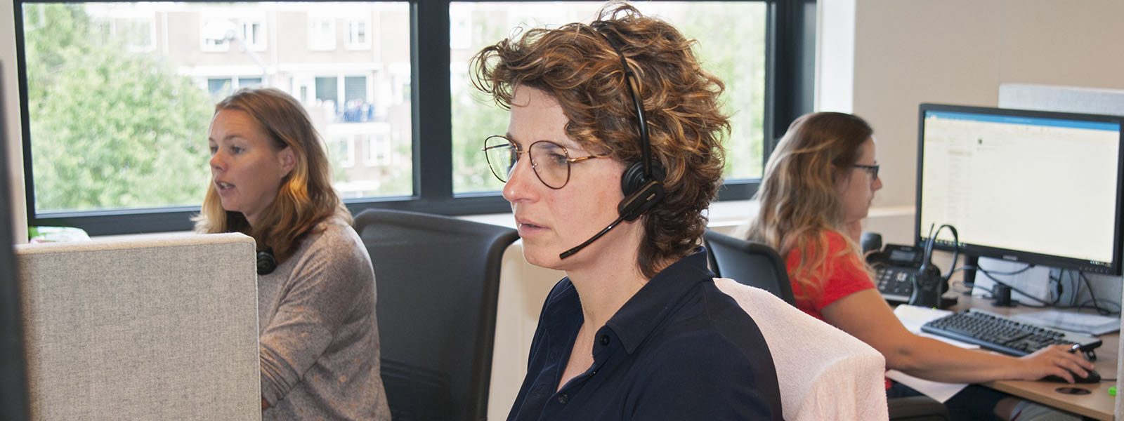 Mevrouw met headset werkend in klantrelaties